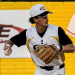 Shortstop, Mark-Anthony Carrol, fields a grounder and prepares a throw to first base.