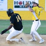 Shortstop, Mark-Anthony Carrol, readies his throw to first base after tagging second to complete the double-play.