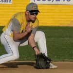 Infielder with glove on the ground to scoop up an incoming ground ball.