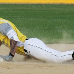 Base runner, Colby Rafail, slides head-first into second base.