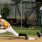 First baseman, Andrew Mora, stretches to receive the ball and earns the putout, with the baserunner inches from stepping on the base.