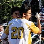 Base runner, Dom DeCanio, tapping helmets with teammate, Colby Rafail, at home plate to celebrate a home run (photograph by Bill Wagner).