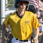 Colt 45s batboy returns to the dugout from home plate carrying player equipment.